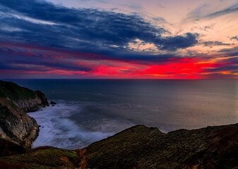 Fototapeta na wymiar Coastal cliffs and silky ocean by Devil's Slide trail in California at sunset