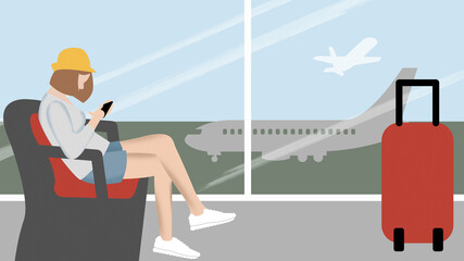 Single female traveler sits in airport lounge using smartphone
