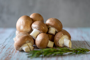 Mushrooms scattered on a light old wooden table.