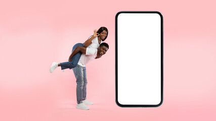 Couple showing white empty smartphone screen and okay gesture