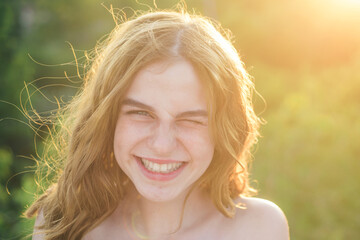 Spring romantic young woman portrait. Young teen woman with clean fresh skin. Close up portrait of smiling teenager, closeup face of beautiful girl outdoor. Soft sunny sunlight on sunny spring day.
