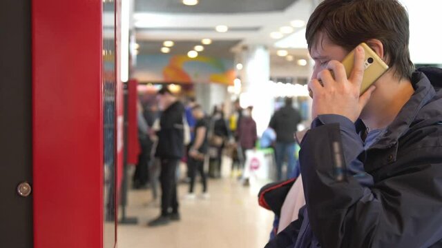 Woman types on fastfood restaurant interactive order board while her husband talking phone