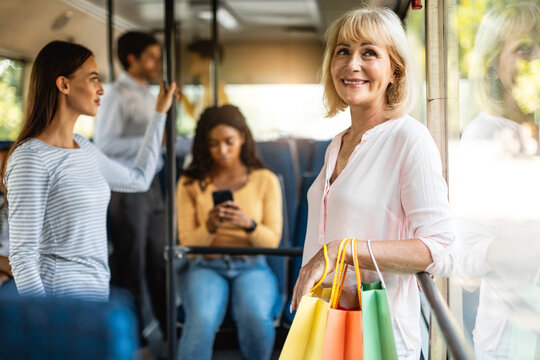 Beautiful Smiling Mature Woman Taking Bus, Holding Shopping Bags