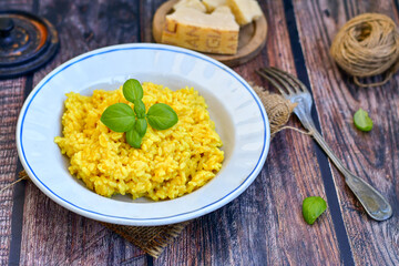  Italian  creamy risotto milanese  with parmesan cheese and fresh basil on rustic background