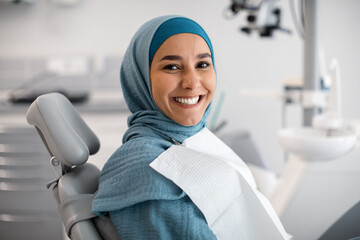Stomatologic Treatment. Happy Young Islamic Woman In Hijab Sitting In Dentists Chair
