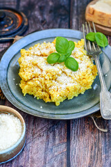  Italian  home made  creamy risotto milanese  with parmesan cheese and fresh basil on rustic background
