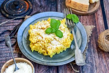  Italian  home made  creamy risotto milanese  with parmesan cheese and fresh basil on rustic background