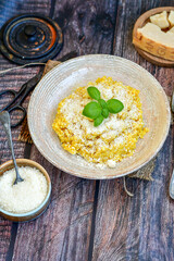  Italian  home made  creamy risotto milanese  with parmesan cheese and fresh basil on rustic background