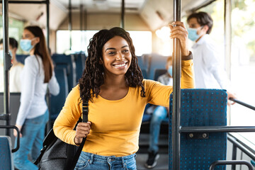 Beautiful smiling black woman standing in bus