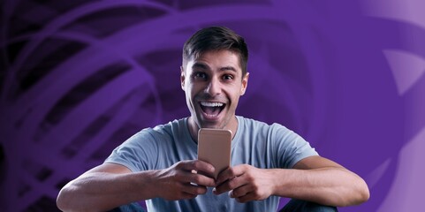 Portrait of excited handsome young man looking at the mobile phone