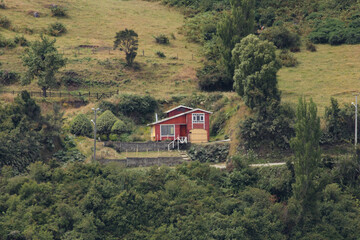 Fototapeta na wymiar Cotagge house on the hillside with trees