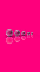 Five balls of metal of different sizes of gray color on Magenta Pink background. Growth of something. Progress. Reflection. Vertical image. 3D image. 3D rendering.