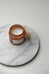 Brown glass candle jar from above. Minimal geometric white and marble background. Product still life photography concept