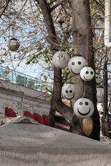 Hanging smiley face balloons on tree. Positive photo. Vertical banner.