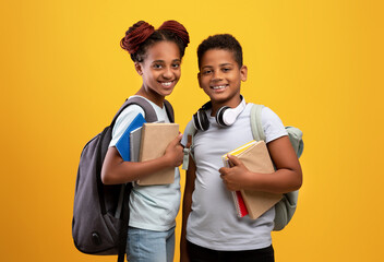 Positive black boy and girl schoolers holding books