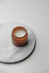 Brown glass candle jar from above. Minimal geometric white and marble background. Product still life photography concept