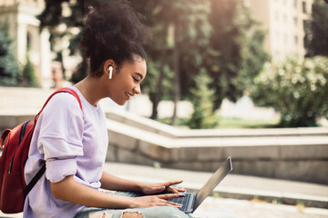Happy African American Student Girl Browsing Internet On Laptop Outdoors