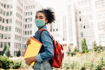 Black Female Student Posing In Medical Face Mask Standing Outside