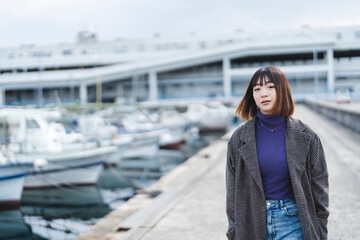 Obraz premium 港を散策する若い女性
