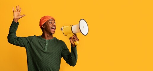 Portrait Of Joyful Black Guy With Megaphone In Hands Making Announcement, Excited African Man...
