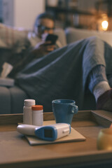 Sick woman on the couch and flu supplies