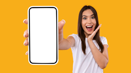 Excited woman showing white empty smartphone screen