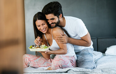 Romantic happy couple having breakfast in bed