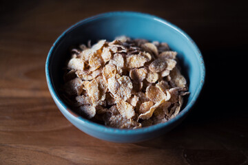 flakes in blue bowl on wooden table