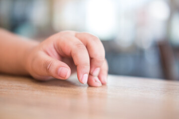 The hand of the child on wood table