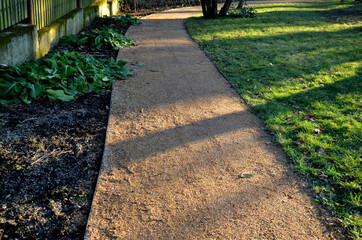 compressing the gravel of the new park threshing path. lawn seed is repaired by rolling a metal...