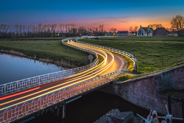 Curve light trails on country road in the landscape of the province of Groningen, The Netherlands © fotografiecor