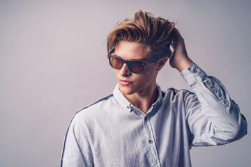 Obraz premium Male hairstyle concept. Handsome man with stylish haircut in sunglasses over white background