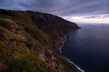 Fototapeta na wymiar Blue hour over the rocky cliffs on the west coast of Madeira, seen from “Miradouro do Fio” viewpoint near Ponta do Pargo