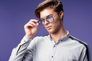 Handsome young guy in stylish eyewear while looking away. Stylish hairstyle. Fashion man