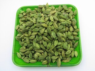 Green cardamom in a plate on white background 
