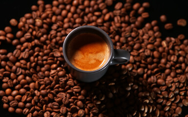 Espresso coffee cup with roasted coffee beans around it