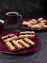 Traditional australian dessert iced vovo. Biscuit cookies with fudge and raspberries jam, sprinkled coconut flake . Keto dessert made from almond flour, sweetener instead of sugar.