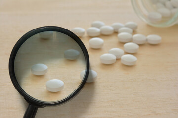 Magnifying glass and white pills