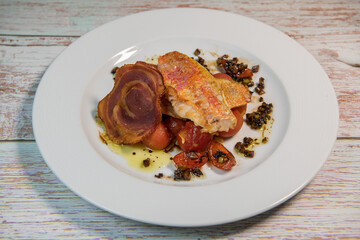 Fish recipe, Fillet of red mullet, crushed cherry tomatoes and olives. High quality photo