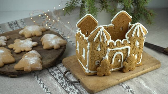 Gingerbread house Christmas homemade baking. Gingerbread Man. astle with white icing. Cookies in the shape of a Christmas tree and snowflakes on the table. Food for dessert. Winter gingerbread.