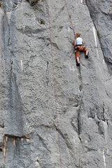 Female climber with harness in the stone wall