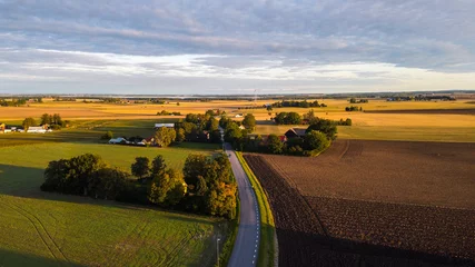 Foto op Aluminium Aerial panorama of Swedish countryside, Swedish village at sunrise, clear blue sky, green yellow fields. View of typical landscape of southern Sweden.  © Clara