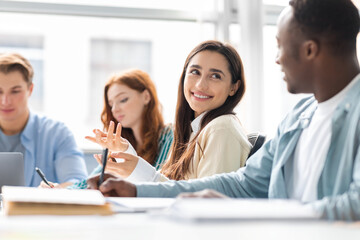 International group of people sitting at desk and talking