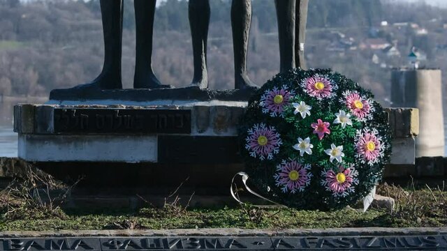 Flower Wreath at Memorial Monument with Bronze Figures