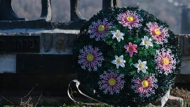 Colorful Artificial Flower Wreath on Cemetery Grave
