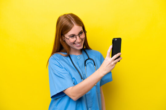 Young redhead nurse woman isolated on yellow background making a selfie