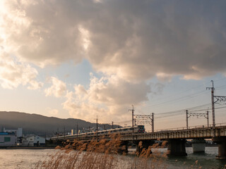 夕暮れの瀬田川の鉄橋を渡るJR琵琶湖線の電車