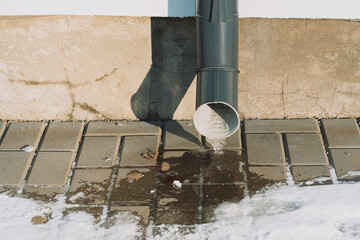 Drainpipe with frozen water on a private house.