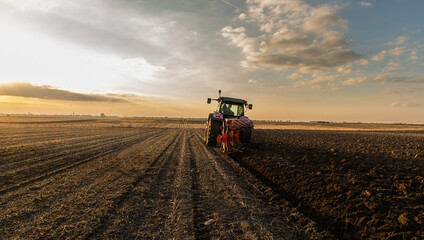 Tractor on the field during sunset.