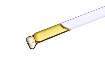 close-up of a serum oil pipette with a falling drop on a white background	
